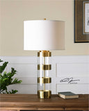Metal bands finished in a plated brushed brass separated by clear acrylic details. The round hardback drum shade is a light beige linen fabric with natural slubbing.