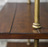 Etagere in an antique brass finish with suspended dark honey stained display shelves