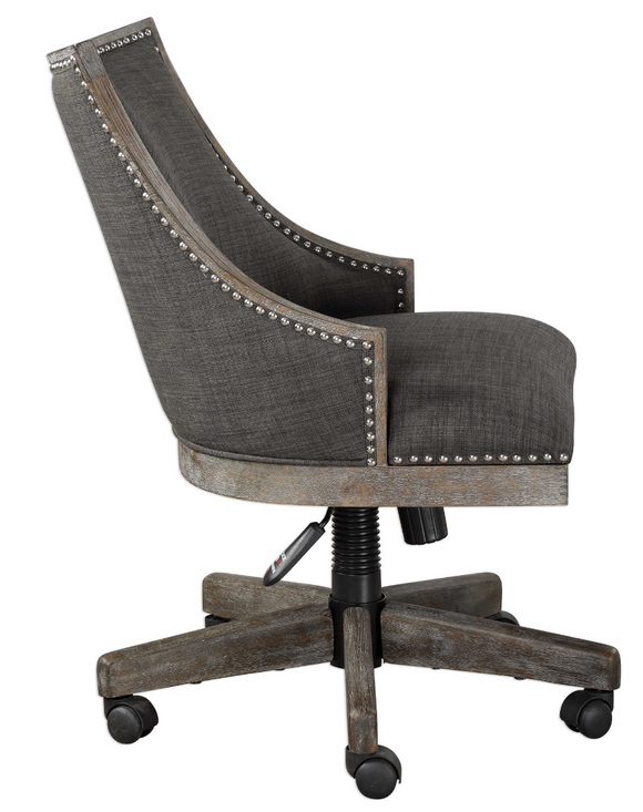 The Steward Office Chair has a curved back design in warm charcoal gray linen, accented by polished nickel nailhead trim. Honey stained frame is finished with a heavy gray wash. 