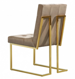 The Quaid Dining Chair has a Hollywood glam look that will take your dining area to another level. Pair this chair with the Quaid Dining Table to complete the look. A boxy geometric shape makes this chair an uber modern addition to your space, while a base of stainless steel makes it durable and tough, so it holds up to heavy daily use. The gold tone finish on the base contrasts nicely with the velvet upholstery used on the seat and back. Heavy tufting adds to the rich appeal of this beautiful design.